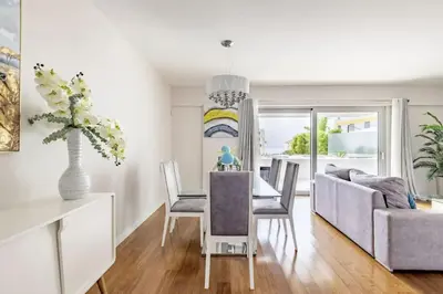 a dining room with a table and a couch at Luxury poolside view apartment in Funchal