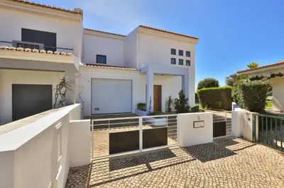 a white house with a gate and a balcony at The Green Sheep Sagres in Sagres