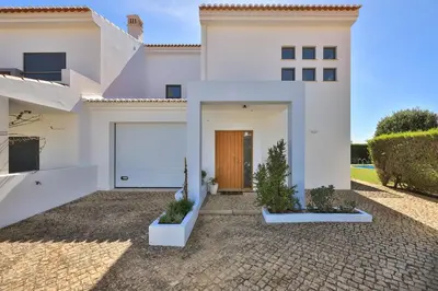 a white house with a door and a driveway at The Green Sheep Sagres in Sagres