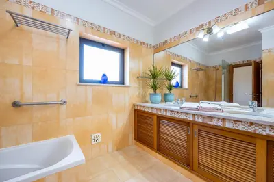 a bathroom with a tub and a sink and a mirror at The Green Sheep Sagres in Sagres