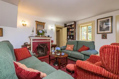 a living room with two couches and a fireplace at Casa dos Castanheiros in Camacha