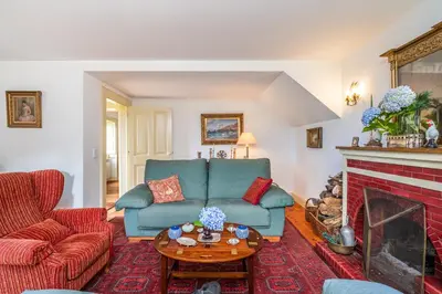 a living room with a blue couch and a fireplace at Casa dos Castanheiros in Camacha