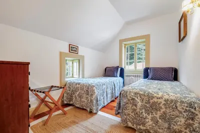 a room with two beds and two windows at Casa dos Castanheiros in Camacha