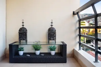 a table with three potted plants on a balcony at Apartamento Caires in Funchal
