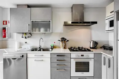 a kitchen with a sink and a stove top oven at Apartamento Forum View in Funchal
