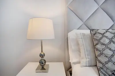 a lamp on a table next to a bed at Apartamento Forum View in Funchal
