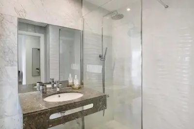 a bathroom with a sink and a glass shower at Apartamento Forum View in Funchal