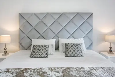 a bedroom with a large white bed with two lamps at Apartamento Forum View in Funchal