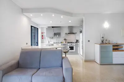 a living room with a couch and a kitchen at Apartamento Forum View in Funchal