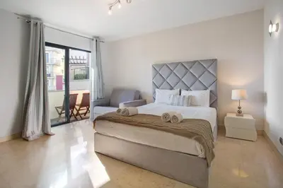 a bedroom with a large bed and a chair at Apartamento Forum View Studio in Funchal