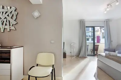 a bedroom with a yellow chair and a bed at Apartamento Forum View Studio in Funchal