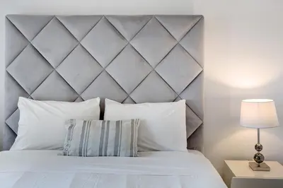 a bedroom with a white bed with a large headboard at Apartamento Forum View Studio in Funchal