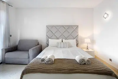 a bedroom with a large bed and a chair at Apartamento Forum View Studio in Funchal