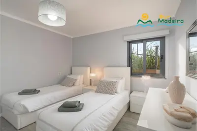 a white living room with two beds and a couch at OurMadeira - OceanScape in Madalena do Mar