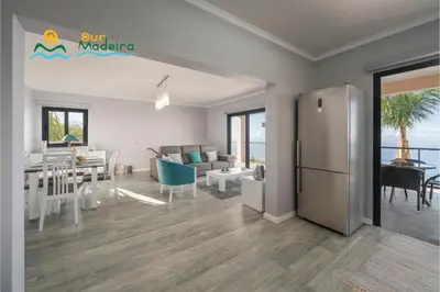 a kitchen and a living room with a refrigerator at OurMadeira - OceanScape in Madalena do Mar