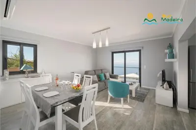 a kitchen and living room with a table and chairs at OurMadeira - OceanScape in Madalena do Mar