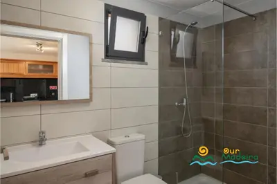 a bathroom with a toilet and a sink and a shower at OurMadeira - OceanScape in Madalena do Mar