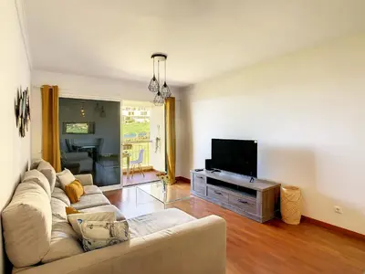 a living room with a couch and a flat screen tv at Vista Atlântica by LovelyStay in Caniço