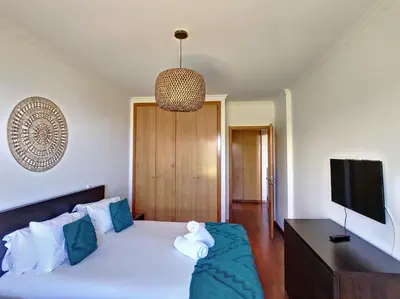 a bedroom with a white bed and a flat screen tv at Vista Atlântica by LovelyStay in Caniço
