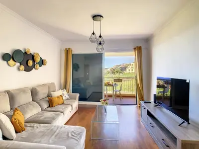 a living room with a couch and a flat screen tv at Vista Atlântica by LovelyStay in Caniço