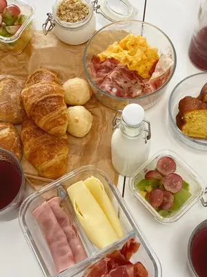 a table topped with different types of bread and pastries at Vi Naturae Glamping in Fajã da Ovelha