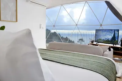 a bedroom with a bed and a large window at Vi Naturae Glamping in Fajã da Ovelha