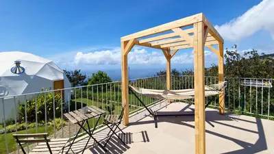 a deck with a chair and a gazebo at Vi Naturae Glamping in Fajã da Ovelha