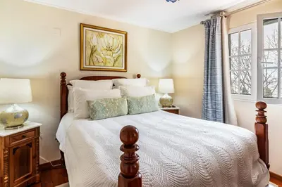a bedroom with a bed and two windows at Villa Retiro in Canhas