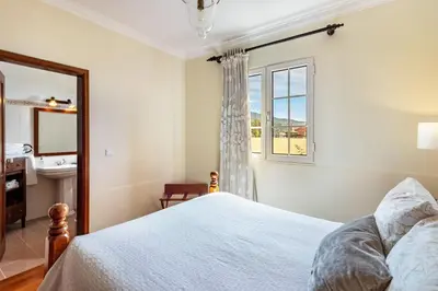 a bedroom with a bed and a window and a sink at Villa Retiro in Canhas