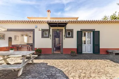 a patio with a table and a building at Villa Retiro in Canhas