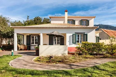 a white house with a tile roof at Villa Retiro in Canhas