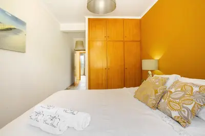 a bedroom with a bed and a wooden cabinet at Retiro Praia in Campo de Baixo