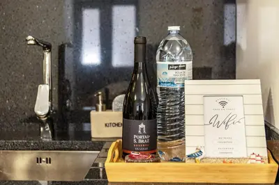 a bottle of wine and a bottle of water on a tray at Casa do Porto in Paul do Mar