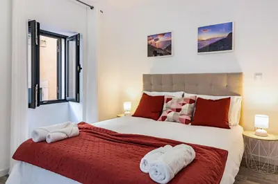 a bedroom with a large bed with towels on it at Casa do Porto in Paul do Mar