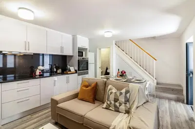 a living room with a couch and a kitchen at Casa do Porto in Paul do Mar