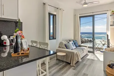 a kitchen and living room with a view of the ocean at Casa Homem do Mar in Paul do Mar