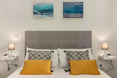 a bedroom with a large bed with two lamps at Casa Homem do Mar in Paul do Mar
