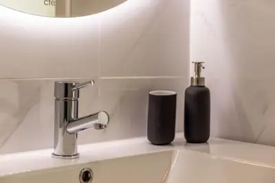 a bathroom with a white toilet and a mirror at Casa Homem do Mar in Paul do Mar