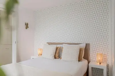 a bedroom with a white bed with two night stands at Casa da Lombada by An Island Apart in Funchal