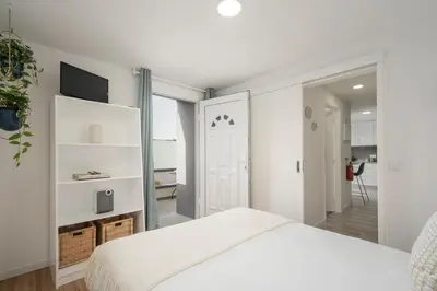 a bedroom with a white bed and a sliding door at Casa da Lombada by An Island Apart in Funchal
