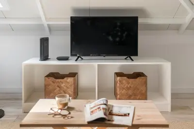 a white entertainment center with a flat screen tv on top at Casa da Lombada by An Island Apart in Funchal