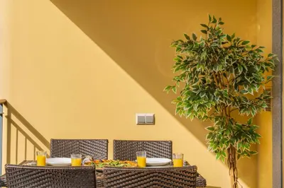 a table with two chairs with food and orange juice at Comboio I by An Island Apart in Funchal