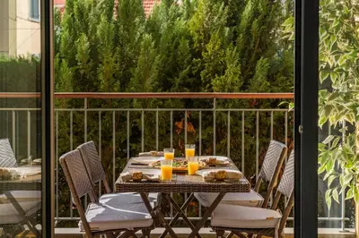 a table on a balcony with chairs and orange juice at Comboio I by An Island Apart in Funchal