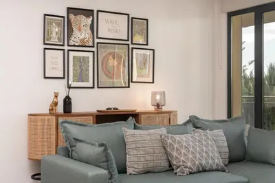 a living room with a blue couch and pictures on the wall at Comboio I by An Island Apart in Funchal