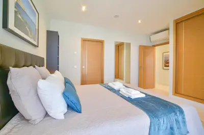 a bedroom with a bed with white and blue pillows at POLA SeaView Apartment by MOJE Holiday in Lagos