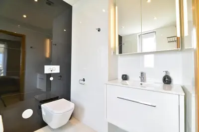 a white bathroom with a toilet and a sink at POLA SeaView Apartment by MOJE Holiday in Lagos