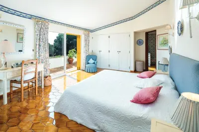 a bedroom with a bed with red pillows and a desk at Quinta Kilara in Luz