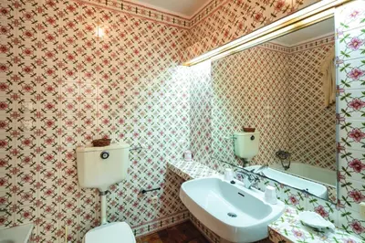 a bathroom with a sink and a toilet and a mirror at Quinta Kilara in Luz