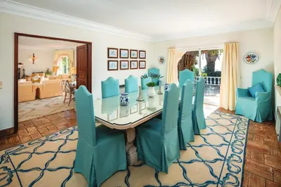 a dining room with a table and blue chairs at Quinta Kilara in Luz
