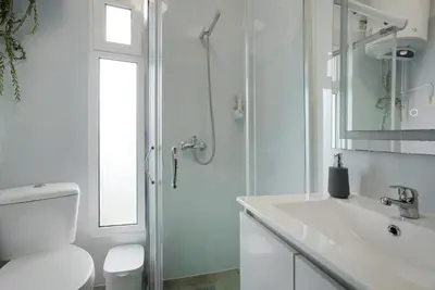 a white bathroom with a toilet and a sink at Apartamento Lolita com Terraço in Caniço